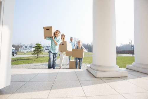 Movers placing boxes into rooms during a Forestgate flat relocation