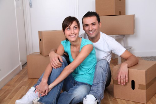 Office movers handling desks and chairs in a Forestgate relocation